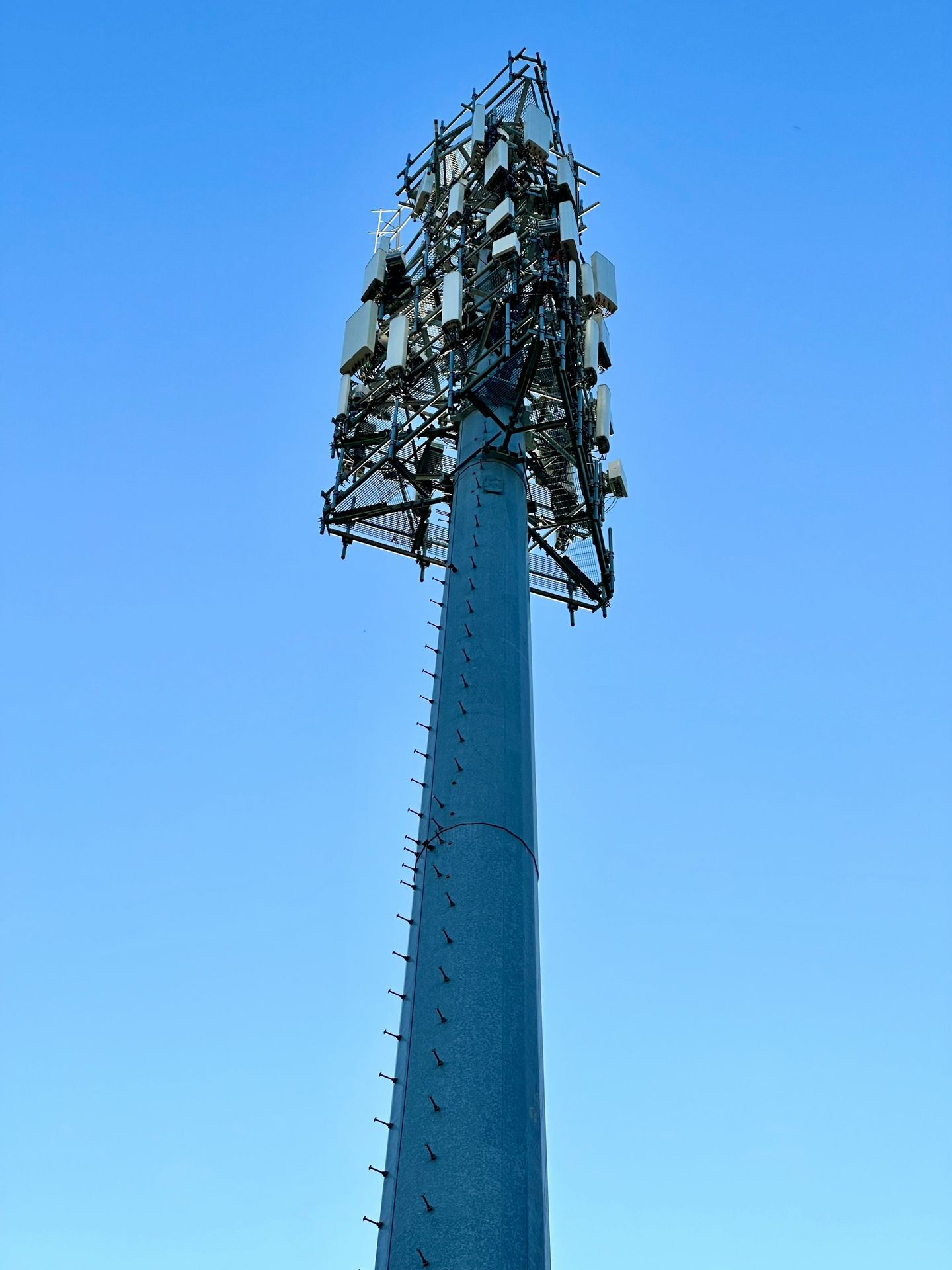 a very tall tower with a bunch of cell phones on top of it